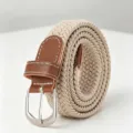 Close-up of beige elastic braided belt with brown leather trim and silver metal buckle - Khaki