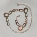 Detailed view of the rose gold metal waist chain featuring interlocking geometric oval links. - Three-Section Gold