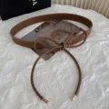 Women's brown PU leather knotted belt, stylish dress and sweater accessory detail view. - Brown