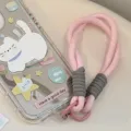 Détail d'une dragonne de téléphone tressée rose attachée à une coque motif chat mignon - Sangle Rose et Grise / Carte Transparente