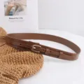 Detail shot of the brown PU leather belt showing pin buckle, strap texture and clean stitching. - 109cm / Dark Brown