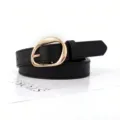 Detail view of retro black faux leather belt with a minimalist gold oval metal buckle - Black