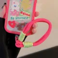 Détail de la dragonne de téléphone tissée rose vif avec accents vert contrastés - Sangle Jaune et Rose / Carte Transparente