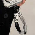 Gros plan détaillé d'un cordon de poignet tressé bicolore pour coque de téléphone - Sangle Grise et Noire / Carte Transparente
