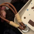 Gros plan macro d'une dragonne de téléphone tressée marron et beige avec anneau - Sangle Marron et Jaune / Carte Transparente