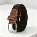 Close-up view of dark brown braided elastic belt with silver buckle and leather trim detail. - Coffee