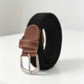 Detail view of black elastic braided belt with silver buckle and brown leather ends - Black