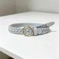 Detailed view of a light blue braided women belt with a gold round buckle for stylish outfits. - Gray