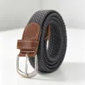Close-up of dark grey elastic braided belt with brown leather accents and silver buckle. - Gray