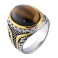 Detailed view of a vintage titanium steel ring featuring a polished oval tiger's eye stone - Size 7 / Two-tone Tiger Eye Stone