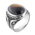 Close-up detail of a vintage titanium steel ring featuring an oval tiger eye stone. - Size 7 / Steel Tone Tiger Eye