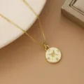 Detailed close-up view of a gold-plated compass star pendant necklace for women's jewelry - Round Tag