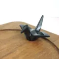 Close-up of a glossy black melamine origami crane chopstick rest on a wooden tray - Black