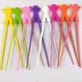 Colorful children training chopsticks with cute silicone doll head, safe and fun toddler tableware. - Random Raising Hand Boy