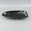 Black melamine plate detail view featuring elegant cherry blossom pattern design for restaurant. - Black
