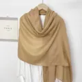 Detailaufnahme des khakifarbenen Baumwoll-Leinen-Schals auf einem weißen Hemd - Camel