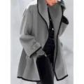 Elegant detail view of a women's oversized grey wool-like coat with black contrast trim - S / Tops / Gray