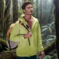 Detail view of a men's light green hooded sun protection jacket worn in outdoor forest. - S / Tops / Green