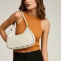 Detalle de un bolso de luna acolchado blanco crema usado como bolso de hombro chic. - Bolso de Axila Luna (MG6025) / Blanco Roto