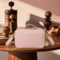 Detailed view of a vintage pink pebbled leather crossbody camera bag with gold hardware - Pink