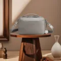 Detailed macro view of a vintage gray leather crossbody camera bag on a wooden stand. - Gray