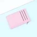 Slim pink faux leather card holder with three card slots and a side zipper closure. - Pink