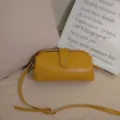 Vista detallada del bolso médico vintage de cuero amarillo con botón metálico - Amarillo