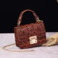 Detalle de mini bolso vintage marrón con relieve de cocodrilo y cierre metálico dorado. - Marrón Cera (PG877 Marrón Cera)