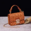 Vista detallata del bolso bandolera vintage naranja con diseño de cocodrilo y cadena oro - Amarillo Tierra (PG877 Amarillo Tierra)