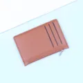 Minimalist slim brown leather cardholder with zipper and three visible card slots - Coffee