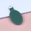 Elegante donkergroene ovale PU-leren sleutelhanger met wit stiksel en gouden ring - Donkergroen