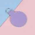 Ronde paarse kunstlederen sleutelhanger met wit stiksel en een metalen ring. - Paars