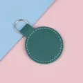 Ronde donkergroene kunstleren sleutelhanger met witte stiksels op gekleurde achtergrond - Donkergroen