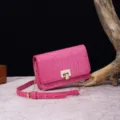 Detalle de un bolso bandolera rosa con grabado de cocodrilo y cierre metálico en dorado. - Rojo Rosa (PG875)