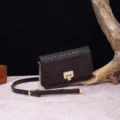 Primer plano de bolso bandolera retro con motivo de cocodrilo marrón oscuro y cierre dorado. - Café (PG875)