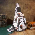 Detailed view of a vintage cow print sling bag with western style leather accents. - Coffee Cow Print (PG5012) / Coffee
