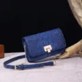 Detalle de un bolso de hombro azul con relieve de cocodrilo y herrajes dorados - Azul Marino (PG875)