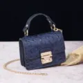 Primer plano de bolso azul marino con relieve de cocodrilo y elegante cierre dorado - Azul (PG877 Azul)