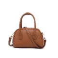 Vista frontal de un mini bolso Boston de cuero marrón con pespuntes blancos y herrajes dorados. - Marrón Dorado