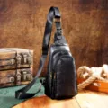 Dettaglio dello zaino monospalla nero retrò con rilievo floreale e fibbie in bronzo - Nero Intagliato