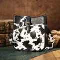 Detail view of a retro Western crossbody bag with cow print pattern and gold hardware - Cow Print Black (PG5057)
