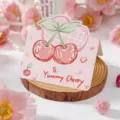 Carte de vœux rose avec gribouillis de cerise et texte Yummy Cherry pour cadeau - Petite Cerise (2026053102)