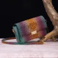 Vista detallada de un vibrante bolso bandolera de cuero con relieve de cocodrilo. - Verde azulado