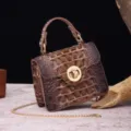 Detail view of vintage brown crocodile embossed leather handbag with golden turn lock - Beige and Brown
