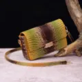 Detalle de bolso bandolera vintage con textura de cocodrilo y broche metálico - Marrón + Naranja Pez Dorado