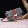 Detalle de un bolso bandolera vintage con relieve de cocodrilo en tonos azul y marrón - Rojo Azufaifa y Marrón