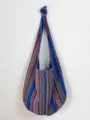 Bolso hobo vintage de algodón y lino con rayas aztecas colgado en una pared blanca - Jacquard Azteca Azul (MG2233) / Azul (Lino de Algodón)