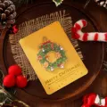 Festive yellow Christmas card with gold-foiled wreath and Merry Christmas greeting - Christmas Wreath Style