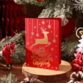 Carte de vœux de Noël rouge rétro avec motif de renne doré et messages festifs. - Style Cerf de Noël / Rouge