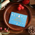 Blue Christmas card with gold foil Merry Christmas text and festive snowman illustrations. - Snowman Style
